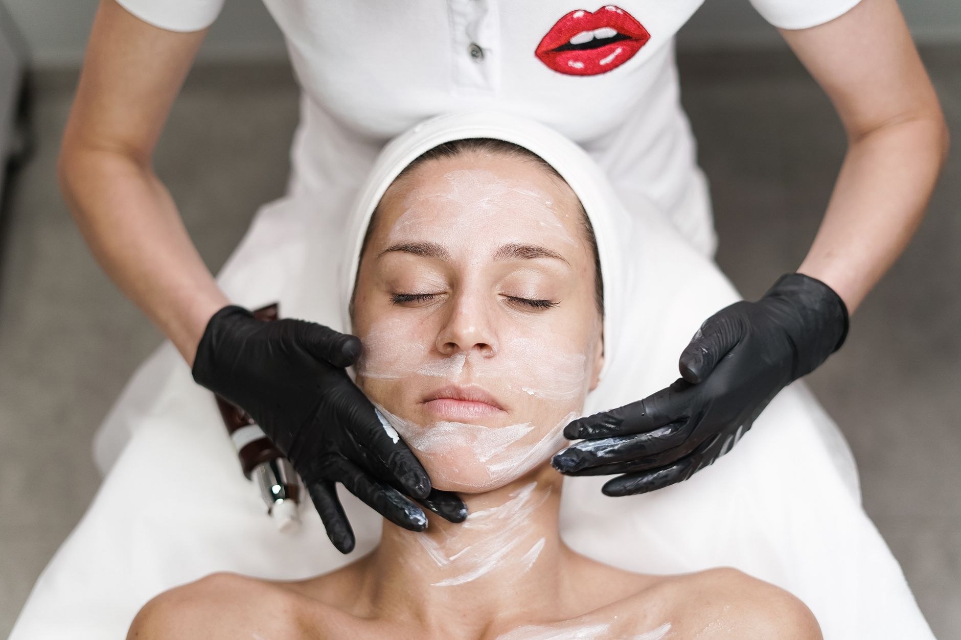 Therapist applying a herbal treatment cream during a facial