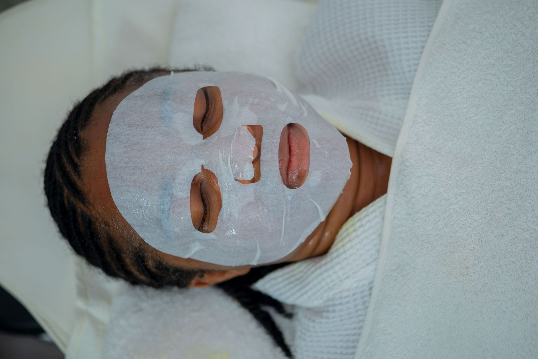 Client relaxing with a hydrating sheet mask